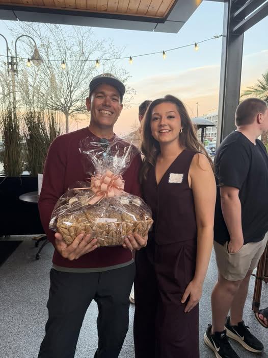 Attendees with a gift basket at sunset during a Networking Night